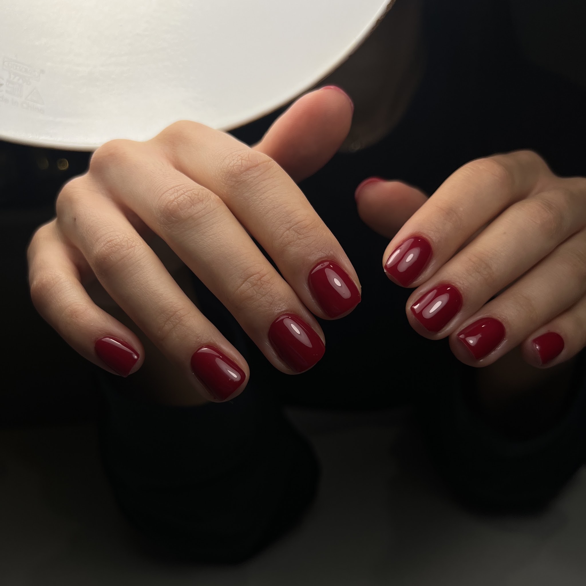 Korte dieprode nagels onder de lamp