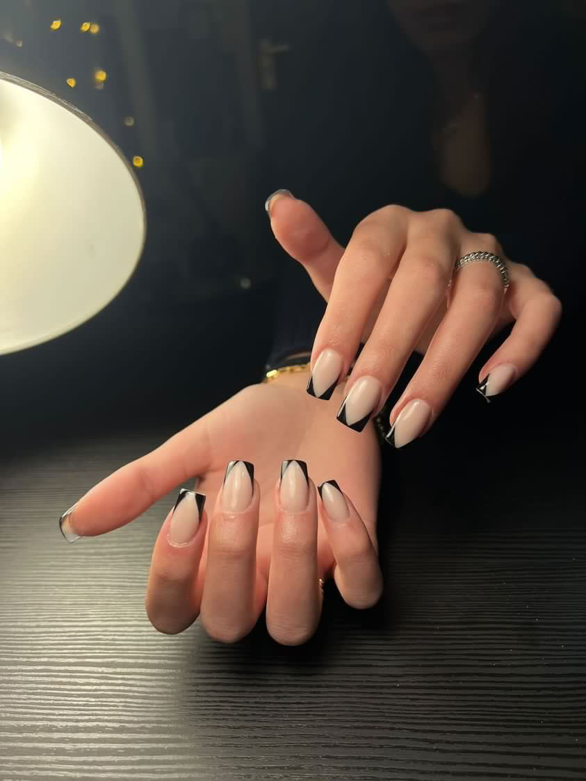 Nude nagels met zwarte v-french onder de lamp, foto van maria hanni